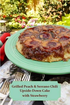 Grilled Peach and Serrano Chili Upside-Down Cake with Strawberry served on a green plate with landscaping in the background.