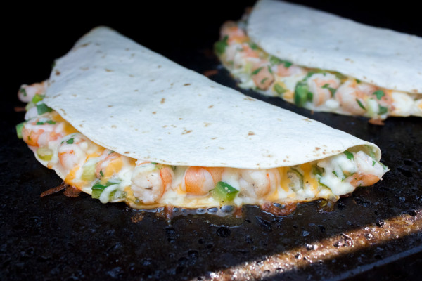 Shrimp and Jalapeno Quesadilla cooking a stone on a grill.
