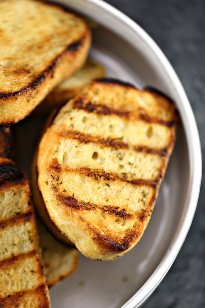 Grilled New York Bakery Texas Toast in a white bowl on a grey counter.